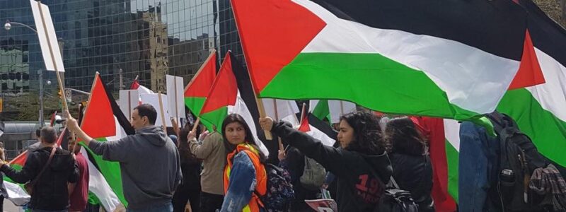 Photographie d'une manifestation pro-palestinienne à Toronto. Les gens portent du keffieh et tiennent des drapeaux palestiniens.