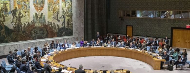A photograph of people sitting around a round table at the UN Security Council