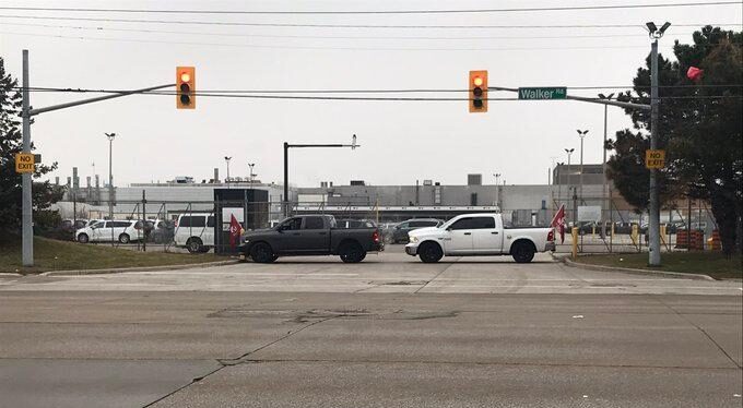 Two pickup trucks block the entrance to an auto plant in Windsor.