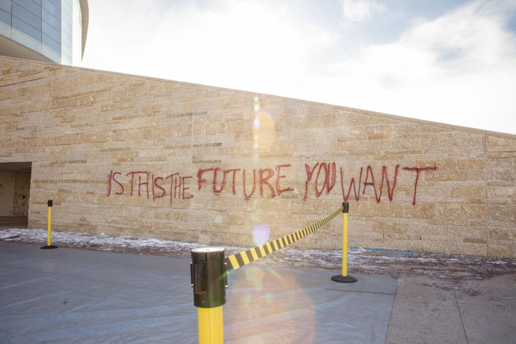 A brick wall, that of the Canadian Museum of Human Rights, spraypainted in red with the words "Is this the future you want?"