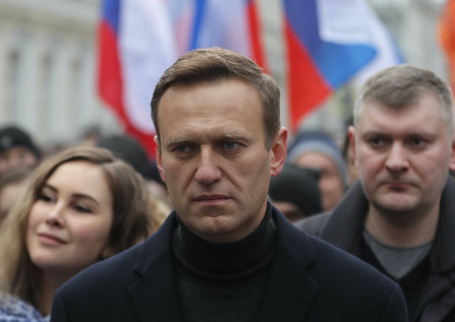 Alexei Navalny marche devant une grande foule tenant des drapeaux russes